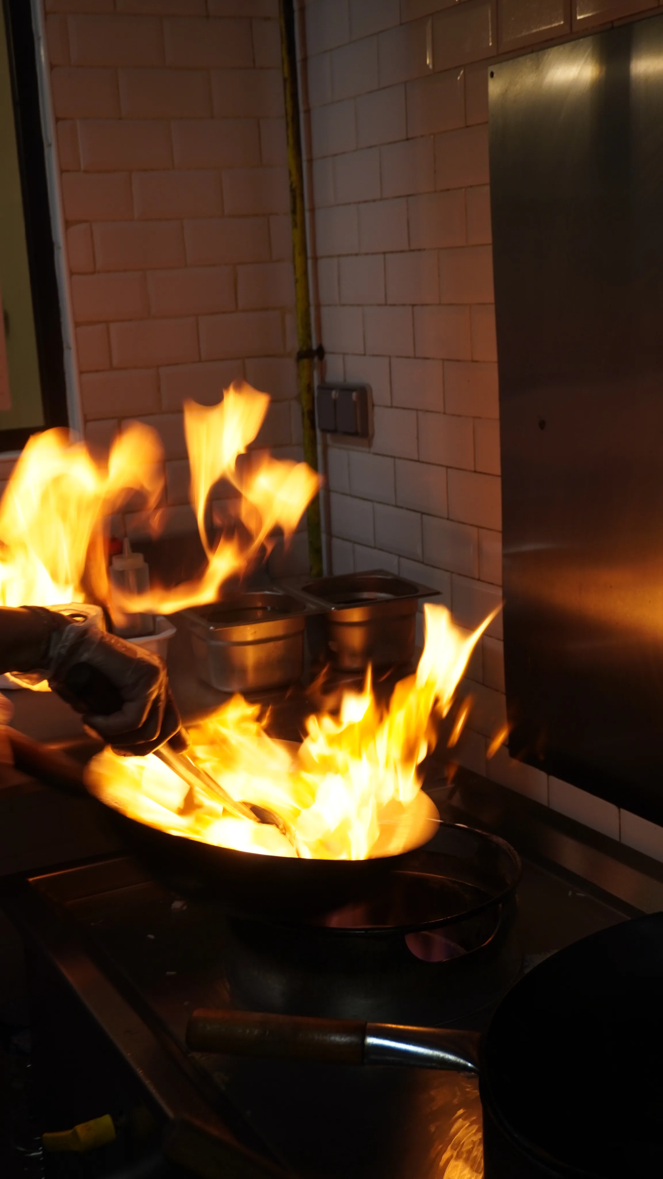 Chef flambant un wok en cuisine